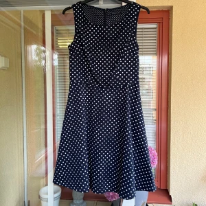 Mörkblå prickig klänning från STOCKH LM - Säljer en superfin mörkblå klänning med vita prickar från STOCKH LM. Klänningen är ärmlös och har en dragkedja på baksidan. Perfekt för fester eller en dag på stan. Den är i nyskick och väldigt bekväm att ha på sig. 