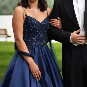 Mörkblå långklänning med spets och pärlor - kollar intresset på min balklänning💙💙Mörkblå fin färg med dragkedja och fina diamantliknande stenar runt midjan✨ tillbehör finns till klänningen💙 Fler bilder finns för intresserade💙Skräddarsydd och egenbeställd för 5500kr, använd 1 gång💙