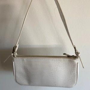 Handväska - Vit handväska Sitter stabilt under axelpartiet så svårare att någon tar den  Från Gina Tricot Använd ett flertal gånger  Bra skikt  Lite lösa trådar  Blekt Dragkedja