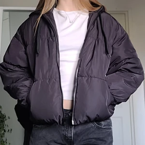 Dunjacka  - En svart dunjacka från H&M med huva. Använd 1-3 gånger, i bra skick.