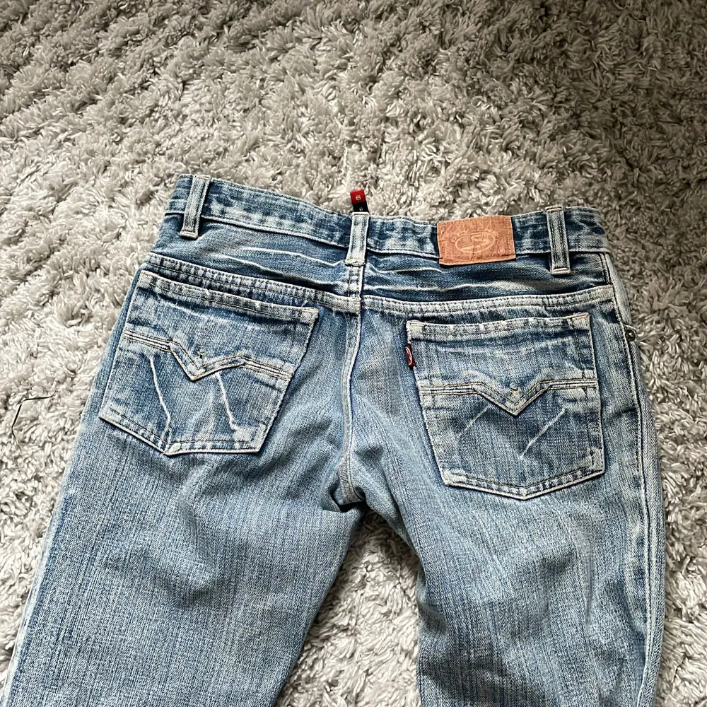 Säljer ett par snygga blå bootcut jeans från Oly-One. De är i storlek L och har en klassisk femficksdesign med knappar och dragkedja fram. Jeansen är i ett användt skick men fortfarande i bra form. Perfekta för en avslappnad vardagslook!. Jeans & Byxor.