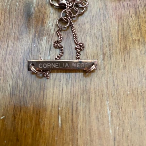 Cornelia Webb armband  - Nytt armband från Cornelia Webb i rosefärg. Längd 27 cm men går att justeras kortare.