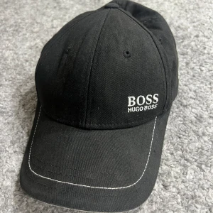 Hugo Boss keps, använt ett fåtal gånger. Den e inte min stil  - I bra skick, passar de flesta huvuden, man kan justera den o göra den större eller mindre 