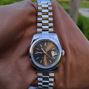 Black/Gold Presidential - Seiko Mod - Helt sprillans ny ”Black & Gold Presidential Datejust - Seiko Mod”. Klockan är byggd för hand av oss, endast uttagen för fotografering. 📸 Utrustad med ett automatiskt NH35 urverk från Seiko och safirglas. 316L stål, verktyg till länkarna medföljer! 📦