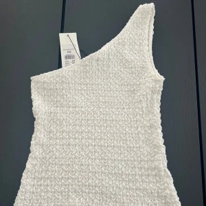 Oneshoulder topp 🤍 - En fin vit topp som aldrig blev använd. Lappen finns kvar! Den kosta 250kr innan men säljer den nu för 200kr. 💓