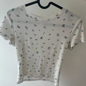 Supergullig blommig t-shirt  - I nyskick. Perfekt längd, precis över jeanskanten 
