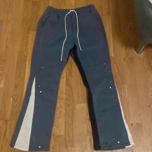 Mörkblå mjukisbyxor med vita och svarta detaljer - Snygga mörkblå mjukisbyxor med vita och svarta sidopaneler. Byxorna har snörning i midjan och en avslappnad passform. Perfekta för en bekväm stil.