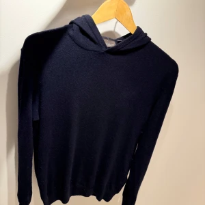 Mörkblå hoodie från Oscar Jacobson - Snygg och stilren mörkblå hoodie från Oscar Jacobson. Är en Kashmir ull blandning perfekt till våren. Nypris ligger på 1600kr mitt pris 900. Den är i bra skick möjligen nån liten defekt nån stans. Bara att skriva vid funderingar!😁
