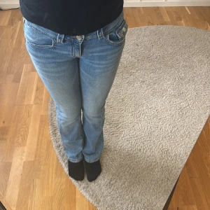 Blå bootcut jeans - Snygga blå bootcut jeans med låg midja och klassisk femficksdesign. Perfekta för en avslappnad stil. De har en knapp och dragkedja framtill.