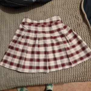 Rutig kortkjol i röd och vit - Säljer en söt rutig kortkjol i röd och vit. Kjolen har ett klassiskt rutmönster. Storleken är uppskattad, den är 140 i barnstorlek men passar xxs och xs