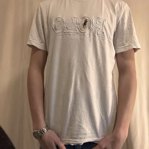 Vit t-shirt från Polo Ralph Lauren - Säljer en klassisk vit t-shirt från Polo Ralph Lauren med broderad logga på bröstet. T-shirten har en normal passform och är kortärmad, perfekt för en avslappnad stil.