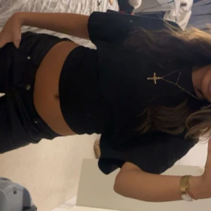 Svart croppad t-shirt - Säljer en stilren svart croppad t-shirt med korta ärmar. Perfekt för en avslappnad look. Passar bra till jeans eller kjol.  Tröjan är från Nelly och har kommit till användning ett par få gånger.💞