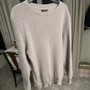 Ljusgrå ulltröja från Stenströms - Säljer en stilren ljusgrå/beige tröja från Stenströms i 100% merinoull. Tröjan har en klassisk rund hals och långa ärmar, perfekt för kyligare dagar. Den är mjuk och bekväm, vilket gör den till ett utmärkt val för både vardag och mer uppklädda tillfällen. Storlek M men passar mer åt S