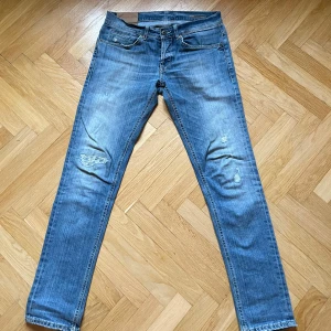 Ljusblå jeans från Dondup  - Snygga blå jeans från Dondup med slitna detaljer på knäna. Perfekta för en avslappnad stil.