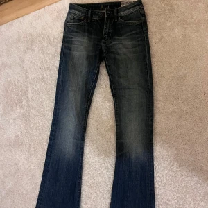 Blå bootcut jeans från Crocker - Jättesnygga lågmidjade blå bootcut jeans från Crocker. Supersnygg passform och wash.