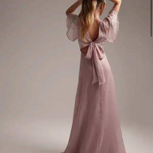 Balklänning - Säljer en helt ny balklänning med prislapp kvar!!!ljusrosa långklänning spetsdetaljer i blommigt mönster. Öppen rygg med knytning, perfekt till speciella tillfällen eller bal!! Nypris - 1 279kr.