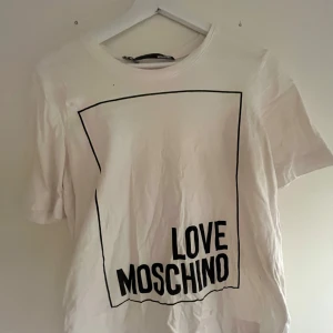 Vit t-shirt från Love Moschino - Säljer en vit t-shirt från Love Moschino, super fin men kommer inte till användning. Finns en liten fläck på nedre delen av tröjan men jag tycker inte den syns vid användning💕