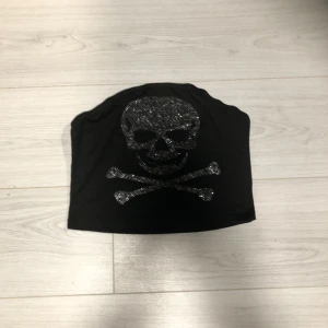 Svart tubtopp med dödskallemotiv - Svart tubtopp med glittrigt dödskallemotiv. Köpte på Plick så vet inte märket 🫶🫶
