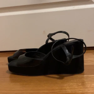 Svarta platåsandaler från H&M - Snygga svarta platåsandaler från H&M med remmar och öppen tå. Sandalerna har en justerbar rem runt ankeln. Bara andvända en gång 🖤