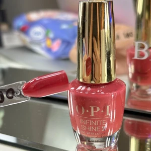 Korall nagellack från OPI - Snyggt korall nagellack från OPI i nyansen 'My Solar Clock is Ticking'. Den tillhör Infinite Shine-serien som ger en långvarig glans. Perfekt för en elegant och hållbar manikyr.