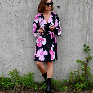 Svart omlottklänning med blommönster från Selected femme - Snygg svart omlottklänning från Selected femme med stora rosa och vita blommor. Klänningen har långa ärmar och är flexibel i storleken pga omlottmoddell.                           Helt ny med lappar kvar. Nypris 1100kr