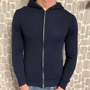 Stenströms merinoull hoodie - Säljer en stilren mörkblå hoodie från Stenströms med dragkedja framtill. 100% merinoull. Mycket bra skick. Står M men sitter som S
