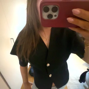 Svart topp från Zara  - En svart topp från Zara med två guldknappar, andvönt typ 3 gånger o säljer för halva original priset!