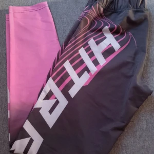 Svart och rosa leggings från HitBrazil - Snygga leggings från HitBrazil i svart och rosa med coolt mönster. Perfekta för träning eller en aktiv dag. Tillverkade i en skön polyester- och spandexblandning för bästa passform och komfort.