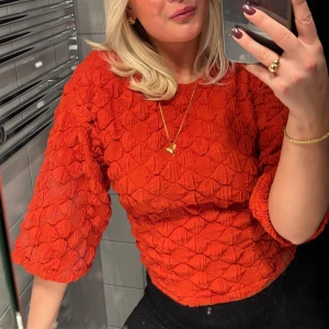 Orange topp med volangdetaljer - Säljer en snygg unik orange topp med trekvartsärmar. Perfekt för att liva upp garderoben! Passar xs-m 🧡köpt på åhlens för bara någon månad sedan, knappt använd. 