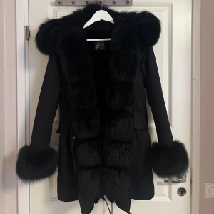 Svart parkajacka - Den är använd men är väl omhändertagen