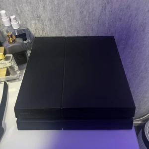 Svart PlayStation 4 - Säljer en svart PlayStation 4 från Sony. Konsolen har en stilren design och är perfekt för gaming. Den är kompakt och passar bra i de flesta rum. Perfekt för att spela de senaste spelen och streama media. 500kr/st, två kontroller finns men de är inte i bra skick 100kr/st