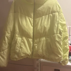 Gul pufferjacka - Säljer en ljusgul pufferjacka med dragkedja framtill. Jackan har en oversized passform och långa ärmar. Perfekt för kyliga dagar med sin quiltade design.