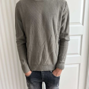 Grå tröja - Snygg grå tröja med lång ärm och rund hals. Perfekt för en stilren och avslappnad look. Passar bra till jeans eller chinos.