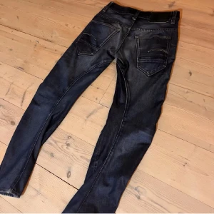 G star jeans - Snygga mörkblå jeans med en klassisk femficksdesign. De har en knappgylf och är tillverkade i ett slitstarkt denimtyg. Perfekta för en avslappnad stil. 