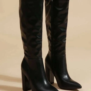 Svarta stövlar med klack - Eleganta svarta stövlar i skinn med hög klack och spetsig tå. Perfekta för en stilren look.