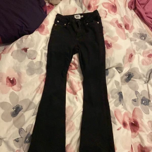Svarta bootcut jeans  Lenght short - Snygga svarta bootcut jeans från 157 i storlek XS. De har en klassisk design med dragkedja och knapp framtill. Perfekta för en stilren look.