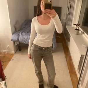Vit långärmad topp - Säljer en stilren vit långärmad topp med rund halsringning. Perfekt för lager-på-lager eller att bära som den är. Passar till både jeans och kjol för en avslappnad look.