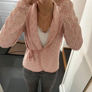 Rosa stickad omlottkofta - Rosa stickad kofta med knytning från Happy Holly i storlek 36/38. Fint skick. Använd gärna köp nu!