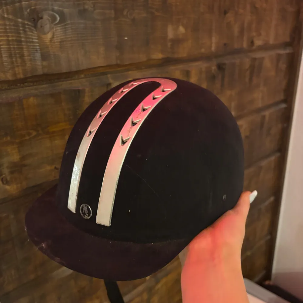 Snygg svart ridhjälm med stilrena silverdetaljer på ovansidan. Perfekt för ridning och ger ett elegant intryck. Passar bra för både träning och tävling.. Asusteet.