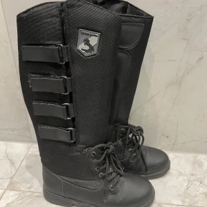 Ridstövlar - Snygga svarta höga ridstövlar  med snörning och kardborreband.  Passar bra för höst och vinter. Håller fötter varma samtidigt som du får ett perfekt stöd när du rider. Använda en gång.   