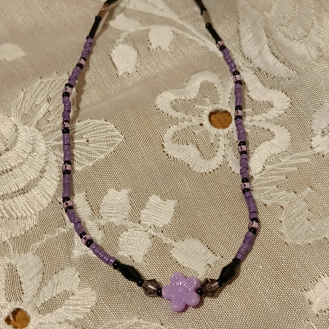 Lila pärlhalsband med blomma - 90