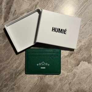 HUMIÉ Korthållare  - Snygg grön plånbok från HUMIÉ med stjärndetaljer. Perfekt för att hålla dina kort organiserade. Kommer i en stilren vit förpackning.