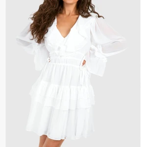 Vit klänning med volanger - Hej! Säljer nu min vita klänning då jag beställde fel storlek, helt oanvänd endast provat, lappen sitter kvar! Perfekt klänning till studenten! Köpt på boohoo för 707 kr säljs nu för 500.