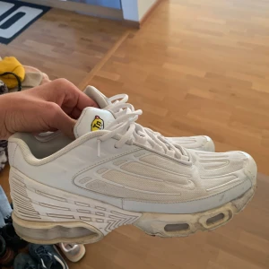 Nike TN - Säljer ett par vita nike TN i syntetmaterial. Skorna har en sportig design med snörning och en synlig dämpning i sulan. De är i välanvänt skick men fortfarande bekväma för vardagsbruk.