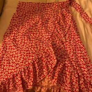 Röd blommig kjol från Shein - Omlottkjol från SHEIN med dragkedja på sidan i storlek S. Aldrig använd! 