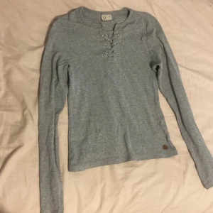 En grå tröja från Ü - Säljer en grå tröja från Ü i storlek 170. De är en rosa liten fläck på armen som inte går bort i tvätten 