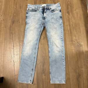 Säljer ett par ljusblå jeans från Pier One. De har en klassisk femficksdesign och en knappgylf. Jeansen har en snygg tvättad look som ger dem en avslappnad stil. Perfekta för vardagsbruk!