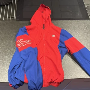 Lacoste jacka - Lacoste regn jacka, använd Max 2/3 gånger är i helt ny skick. Storlek L. Passar stor M
