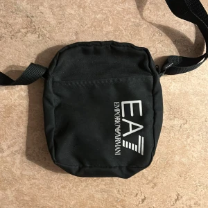 Emporio Armani väska - Säljer väskan för att jag inte har någon användning av den har använt den bara några gånger Men blixt låset som är inne i väskan är tråkigt Men annars så är den bra