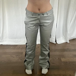 Läderbyxor - Vintage silvriga bootcut byxor från Bray Steve Alan med nitar i äkta läder. Midjemått: 82 cm, 41 cm mätt platt. Innerbenslängd: 85 cm. Har några defekrer längst ner som kan gå bort 🤍